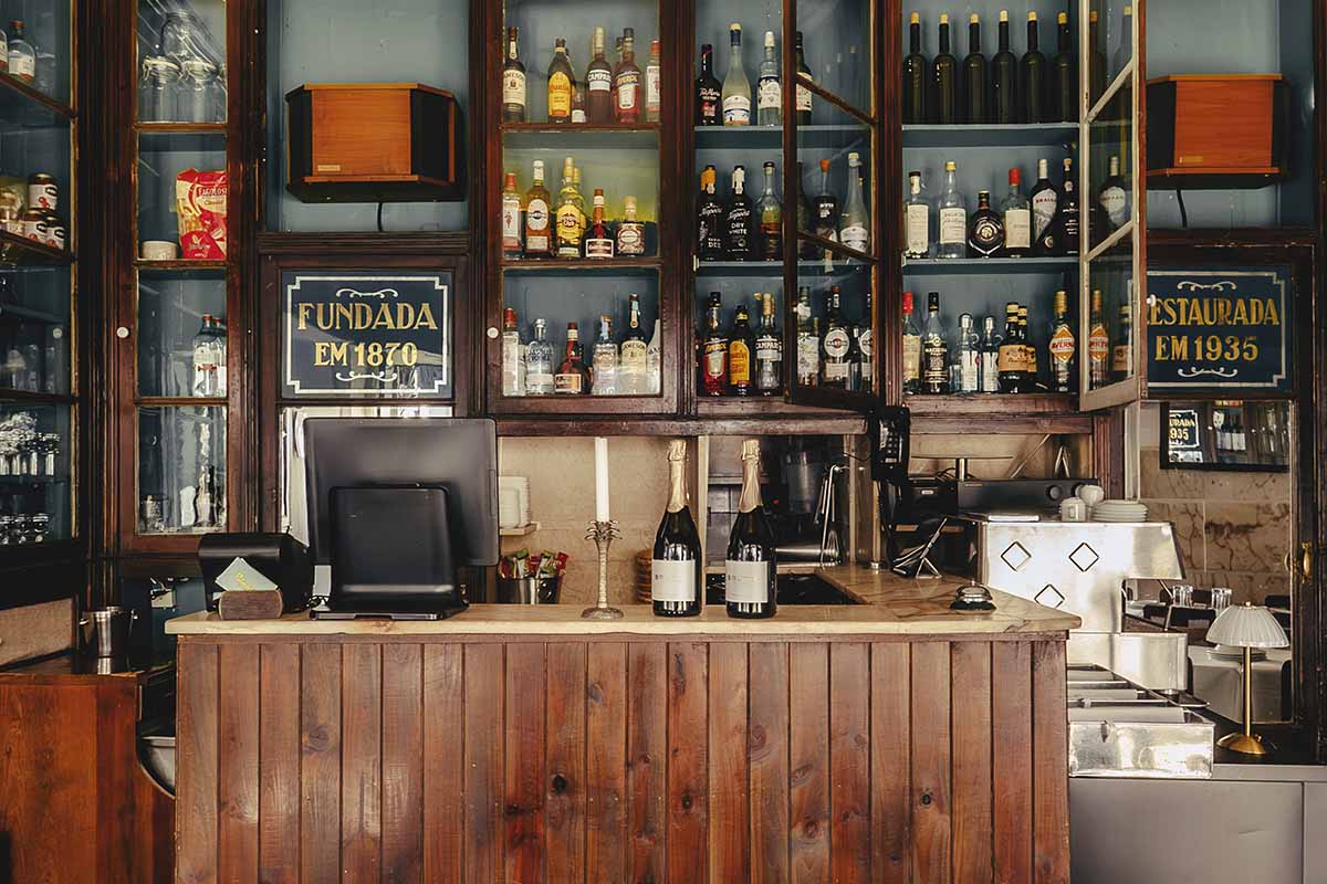 Negroni being prepared at the bar of O Palmeiral restaurant, Príncipe Real, Lisbon — wooden counter, warm lighting